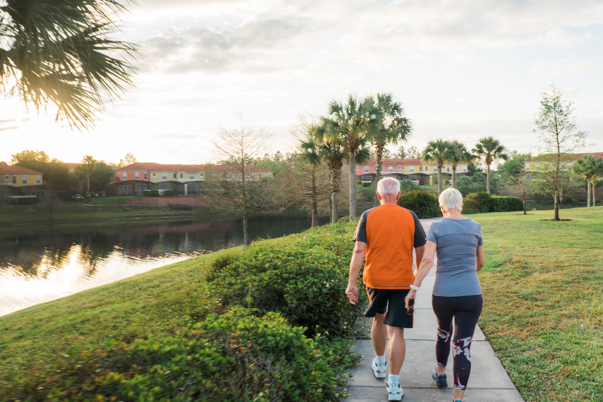 Active Senior adult couple walking together by the lake